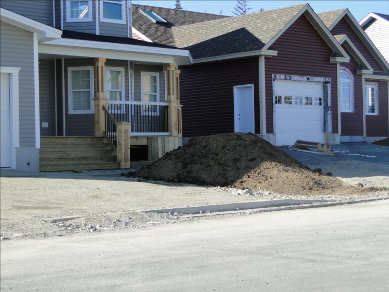 New homes being built with pile of dirt in front yard