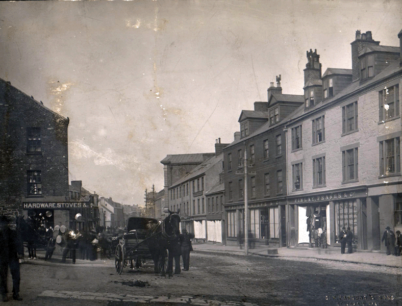 Photo #: 01-11-007  Water Street looking east from the foot of Market House Hill.  Shown are the premises of Finlay and Fraser and Company at 18 Water Street and Walter Grieve and Company at 179 Water Street.  Also shown is a tinsmith on the corner at 188 Water Street, a horse drawn carriage and other mercantile premises.  Dated 1880s