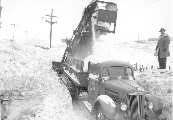 Photo #: 11-01-391  Snow clearing operations on an unknown St. John's street.  The Streets Superintendent Edward Furlong is overseeing the operations.  Dated 1950s