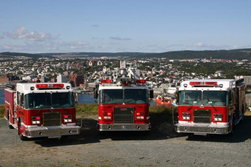 Three fire trucks on Signal Hill with St. John's in the background