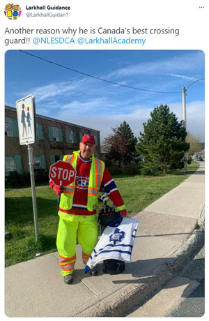 Crossing Guard holding stop sign & wearing a safety vest over a hockey jersey of the Montreal Canadiens hockey team