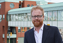 George Murray St. John's Poet Laureate 2014 to 2017 stands in front of the John Murphy building and skywalk