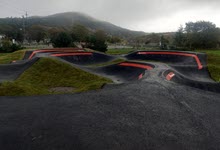 A paved pump track surrounded by grass.
