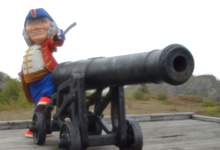 Admiral Johns points his sword toward a cannon