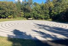 Image of a Labyrinth in Bowring Park, green trees in the background.