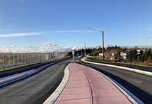 Image shows paved road at Hebron Way with blue sky in the background