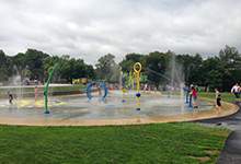children running and playing in spraying water at the splash pad at Bannerman Park