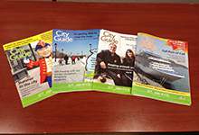 The first four editions of the City of St. John's City Guide publication laid out together on a table