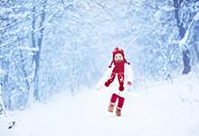 young girl skipping along a winter trail