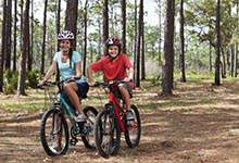Children riding bikes on trail in woods