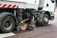 a close up of the brooms, sweepers and wheels of a street sweeping machine