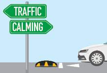 Image of car on road next to sign with words "Traffic Calming"